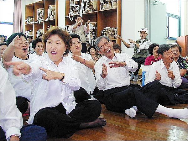 발표회에 참석한 노인들이 노래와 율동을 함께 하며 즐거워 하고 있다. 